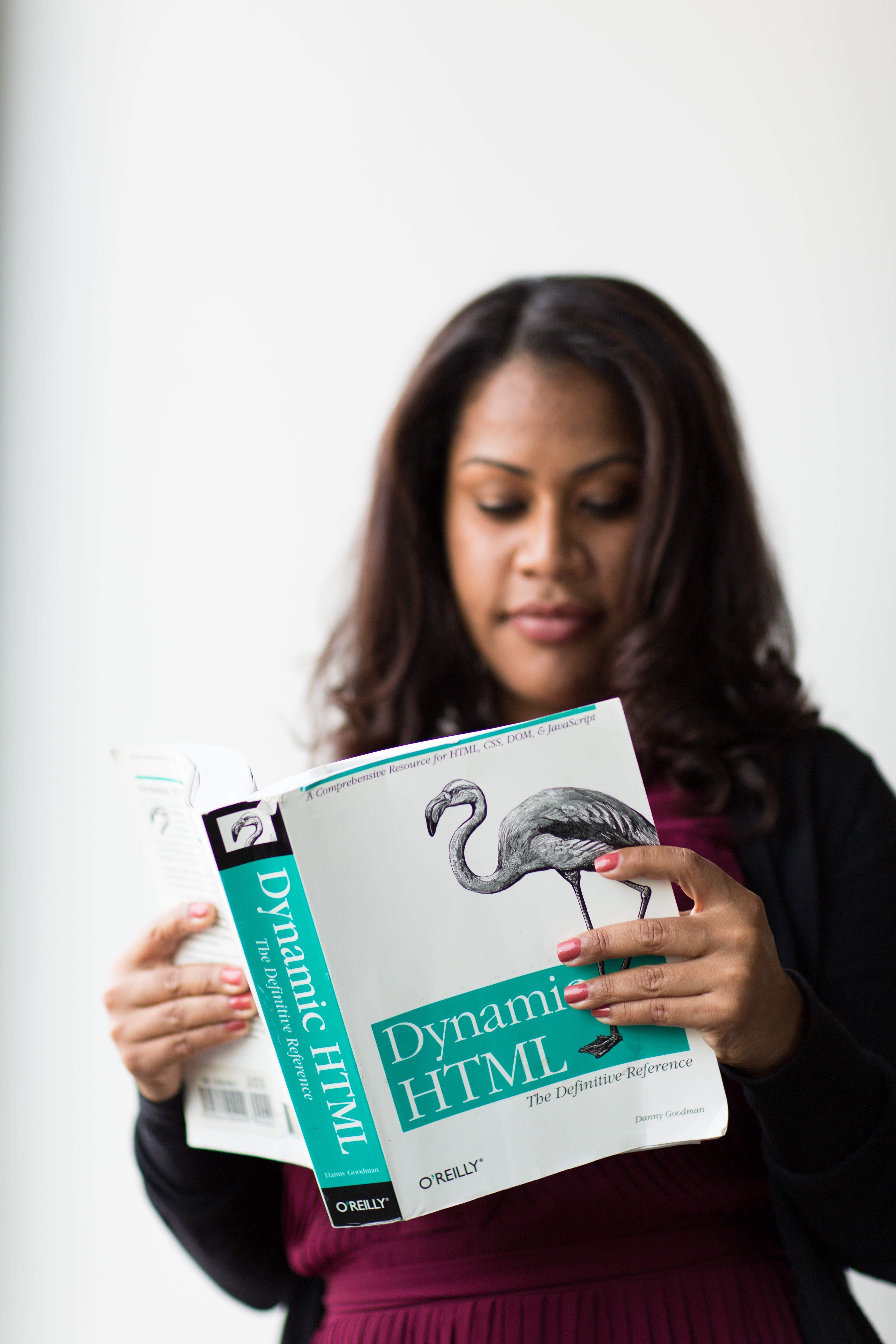 A girl reading a book about html